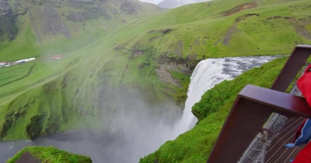 Viajar turista em olhar para cachoeira Skogafoss na Islândia — Vídeo de Stock