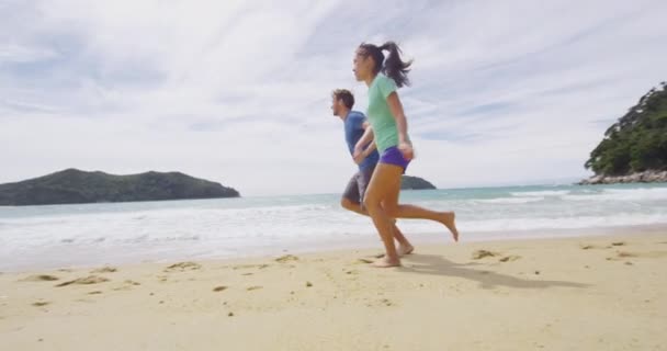 Casal correndo na praia apaixonada se divertindo na Nova Zelândia — Vídeo de Stock