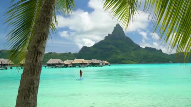 Hotel resort di lusso sulla spiaggia di Tahiti a Bora Bora, Polinesia Francese. Paddleboarding sport acquatici attività ricreative SUP paddle donna, Polinesia francese. Monte Otemanu paesaggio vacanza estiva. — Video Stock