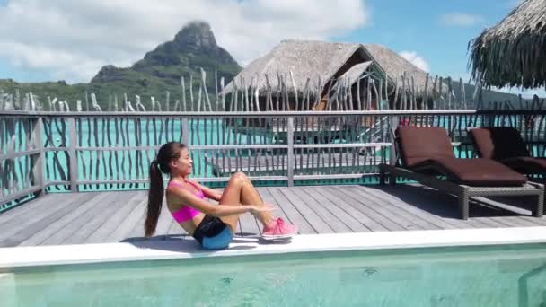 Fitness-Frau am Strand mit durchtrainiertem Körper beim modifizierten V-up Crunch ab Toning Training als Teil eines aktiven Lebensstils. Körpergewichtsübungen im Urlaub auf Bora Bora. — Stockvideo