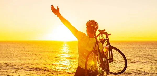 Sukces, osiągnięcie, osiągnięcie i zwycięska koncepcja kolarstwa górskiego. Szczęśliwa MTB kobieta jazda na rowerze podnoszenie ramion rowerem przez morze podczas zachodu słońca doping i świętowanie na szczycie — Zdjęcie stockowe