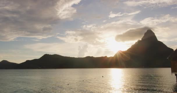 波拉波拉日落海滩度假天堂岛在珊瑚礁泻湖中.Otemanu山，Bora Bora，法属波利尼西亚，塔希提岛，南太平洋，有水上平房的度假酒店 — 图库视频影像