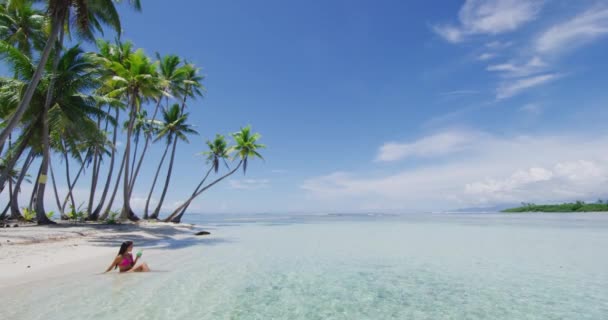 Seyahat kumsal gezisi cennet güneşli kadın güneşleniyor tropikal cennet arka planında güneşleniyor mavi gökyüzü ve palmiye ağaçları ile. — Stok video