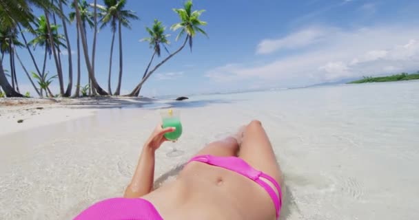 Podróże plaża wakacje kobieta opalanie picia niebieski hawajski napój na słońcu lato relaks tło. dziewczyna ręka gospodarstwa koktajl szkło opalające ciało i nogi — Wideo stockowe