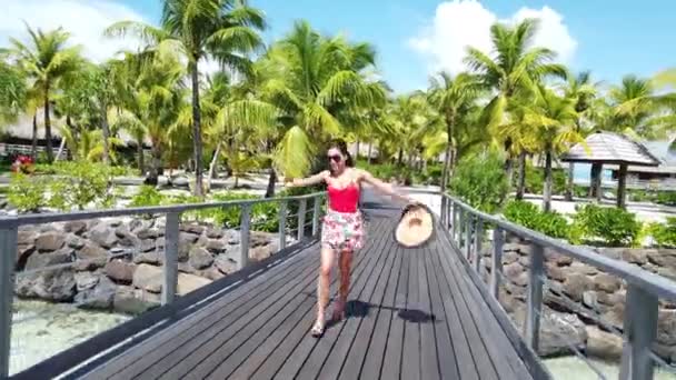 Aufgeregt fröhliches Sommerreise-Konzeptvideo mit einer jubelnden Frau, die freudig aufgeregt rennt und tanzt, um im Luxus-Resort im tropischen Paradies zu sein. Menschen, die Spaß am Reisen haben — Stockvideo