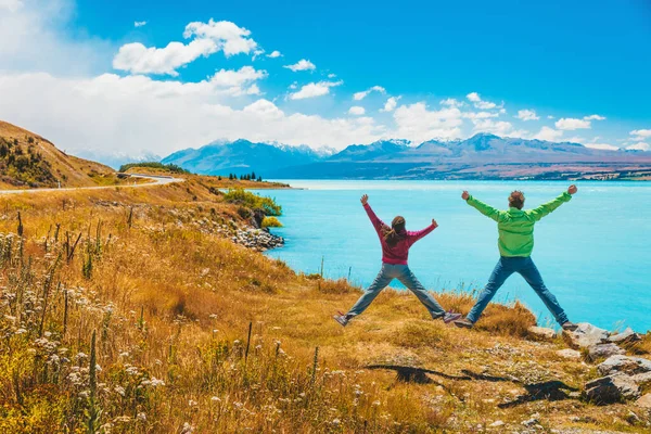 Nueva Zelanda aventura viaje concepto de vacaciones. Feliz pareja emocionada saltando de alegría. La gente en la naturaleza paisaje Isla Sur, por Aoraki aka Monte Cook en Peters mirador, un famoso destino turístico — Foto de Stock