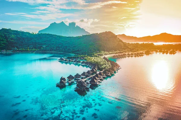 Viagem de luxo aéreo de férias de bungalows submarinos resort em recife de coral lagoa oceano por praia. Vista de cima ao pôr-do-sol da fuga paradisíaca Bora Bora, Polinésia Francesa, Taiti, Oceano Pacífico Sul — Fotografia de Stock