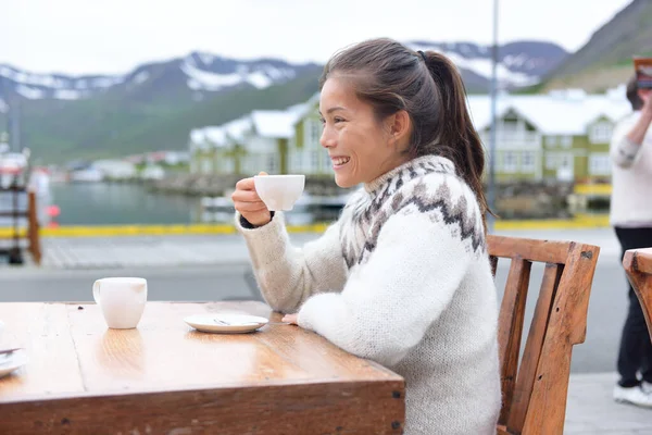 O femeie care bea cafea pe trotuarul cafenelei din Islanda — Fotografie, imagine de stoc