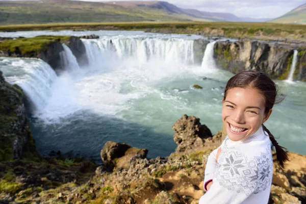 Retrato de mujer en viaje por la cascada Godafoss en Islandia. Felices turistas jóvenes disfrutando de paisaje natural icelandés visitando la famosa atracción turística de destino, Islandia —  Fotos de Stock