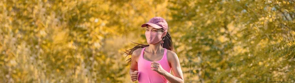 快乐跑步的女人带着面具在秋天的黄色背景横幅上训练 — 图库照片