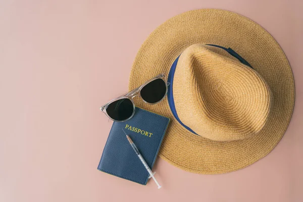 Coronavirus vaccine passport travel objects: flat lay of hat, sunglasses syringe, on pink background. Corona virus certificate proof fortravelers tourists — Stock Photo, Image