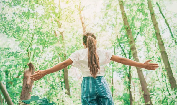 Ropa de moda ecológica sostenible mujer sintiéndose libre con los brazos abiertos en bosques bosque feliz breating aire limpio. Viajar chica turística caminando en un entorno natural saludable recursos renovables — Foto de Stock