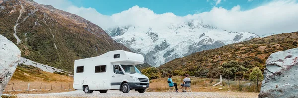 Lakókocsi furgon Új-Zélandon. Egy pár nyaralni megy. A turisták kilátás nyílik Aoraki Mount Cook Nemzeti Park és hegyek mellett bérelt autó. Panoráma felirat — Stock Fotó