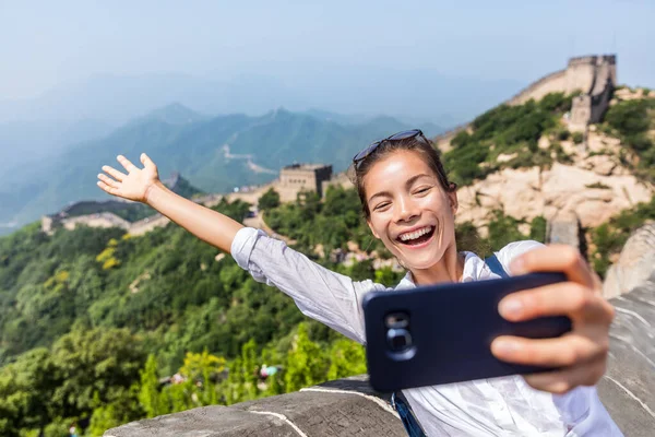 Grande Muralha de porcelana. Turista tirar foto selfie no famoso Badaling durante as férias de viagem no destino turístico chinês. Mulher turista tirar foto usando telefone inteligente durante as férias na Ásia — Fotografia de Stock