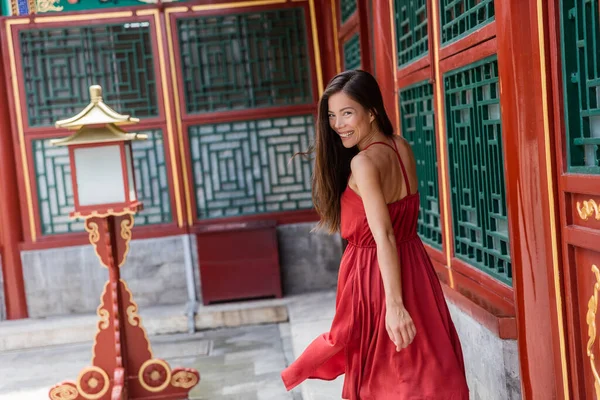 Krásná asijská modelka se směje zdravému životu. Štěstí a radostný životní styl. Čínská žena v elegantní červené hedvábí šaty tanec a běh v Číně cestování — Stock fotografie