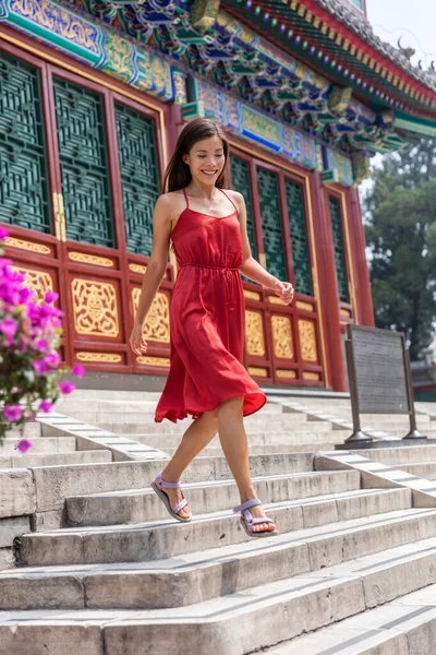 Beautiful young Asian woman walking down the stairs of an old chinese temple, traditional tourist attraction during china summer travel. Girl tourist in Beijing — Stock Photo, Image