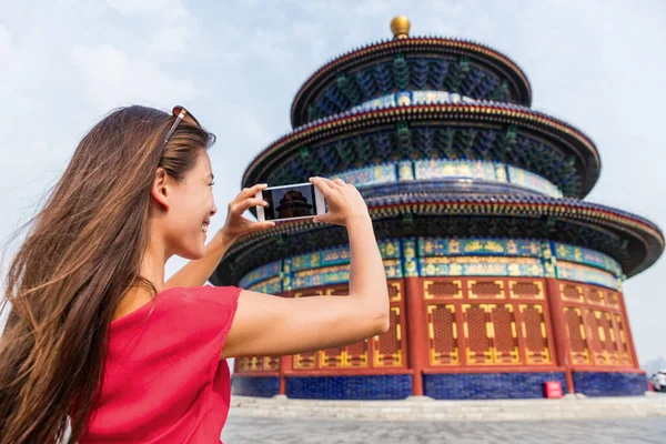 Asia travel chinese woman tourist taking picture with smartphone of the temple of Heaven, a popular tourist attraction which is an imperial building in Beijing city. Famous china landmark — Stock Photo, Image