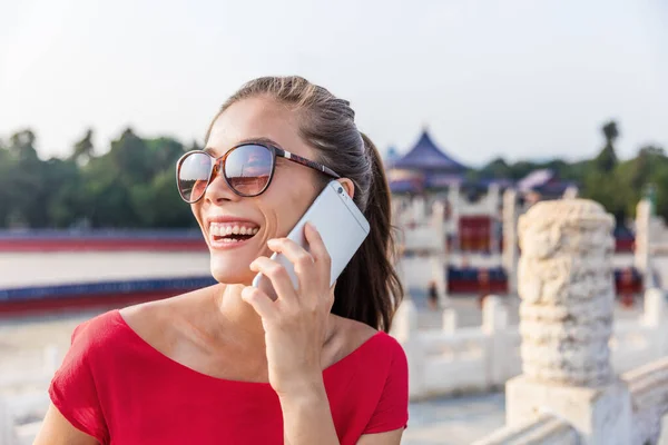 Gelukkige Aziatische vrouw die met iemand aan de telefoon praat. Meisje belt met mobiele app tijdens servies zomer reizen — Stockfoto