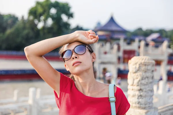 Kvinnlig asiatisk turist utmattad under berömda attraktion besöka semester. Kvinnan bär solglasögon svettas av sol och värme utmattning på varm sommardag i Peking, Kina. Resmål för Asien — Stockfoto