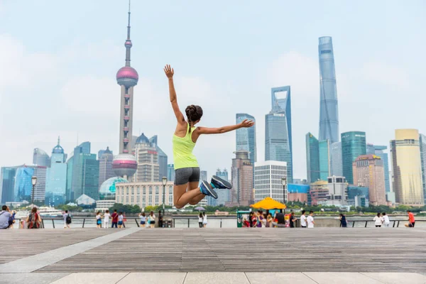 Glad fitness kvinna hoppar i Shanghai skyline — Stockfoto