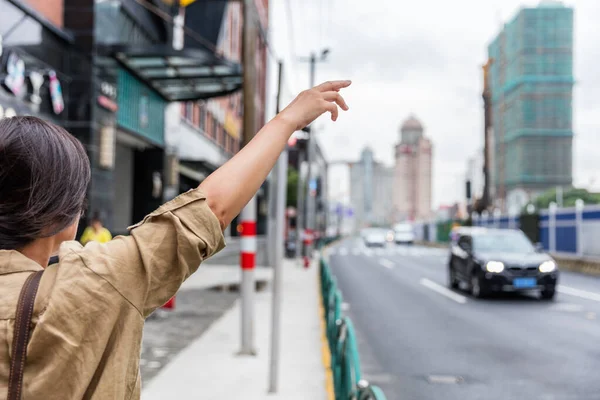 Şangay caddesinde bir araç paylaşım aracını selamlayan bir kadın. — Stok fotoğraf