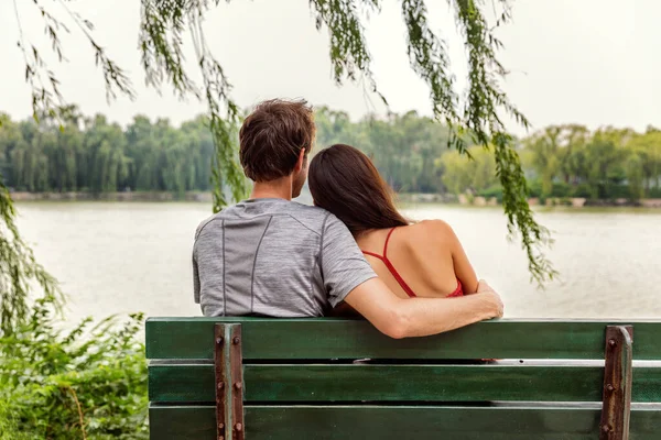 Casal apaixonado - Dois jovens amantes sentados juntos em um banco de parque olhando para a vista do lago romântico. Palácio de Verão de Pequim. Conceito de relacionamento feliz saudável — Fotografia de Stock
