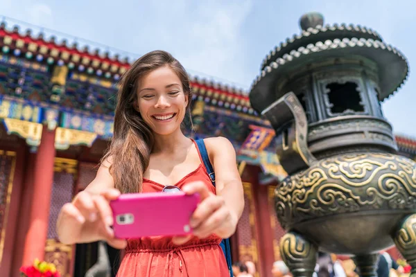 Turist med mobiltelefon ta bilder av gamla tempel brons skulptur i Peking, Kina. Turismresor i Asien. Människor under semester — Stockfoto