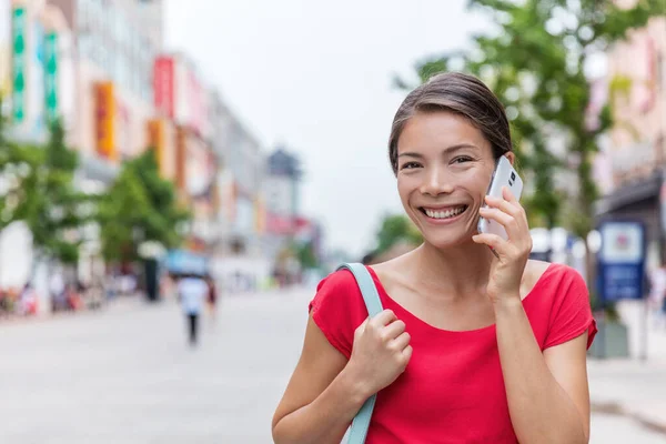 Kinesisk kvinna pratar i telefon medan du går på Wangfujing shoppinggata, Peking stad. Smart casual affärskvinna med mobilapp utanför. Glad asiatisk flicka ringer under porslin sommarresa — Stockfoto