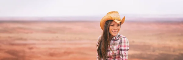 Cowgirl woman smiling happy on country farm landscape wearing cowboy hat. Banner of young multiracial Asian American girl in panoramic countryside — Fotografia de Stock