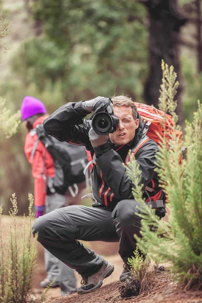 Fotograf Mann fotografiert mit professioneller Kamera Wildtiere in der Natur. Wanderer wandern auf Reisen Abenteuer im Wald mit Ausrüstung, um in freier Wildbahn zu schießen — Stockfoto