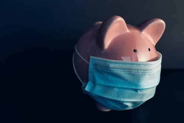 "Global economy during coronavirus pandemic". Une tirelire portant un masque chirurgical. Crise financière, concept bancaire. — Photo