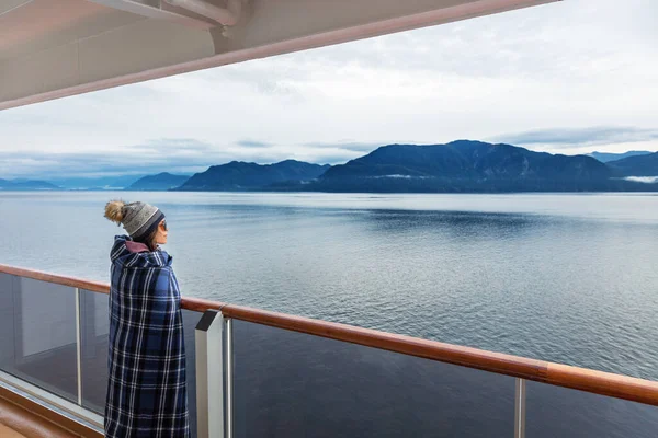 Alaska rejs podróży luksusowe wakacje kobieta oglądanie wewnątrz pasażu malownicze rejs dzień na balkonie pokładzie ciesząc się widokiem na góry i krajobraz przyrody. Azji dziewczyna turysta z wełny koc. — Zdjęcie stockowe