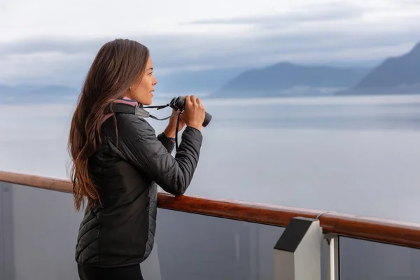 Alaska crucero mujer en la observación de ballenas excursión en barco mirando la vida silvestre con prismáticos. Turista en el interior del pasaje Glacier Bay destino de vacaciones en barco de viaje disfrutando de crucero panorámico. —  Fotos de Stock