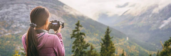 Travel tourist woman photographer taking pictures with video camera of nature landscape Alaska background, panoramic banner. — Stock Photo, Image