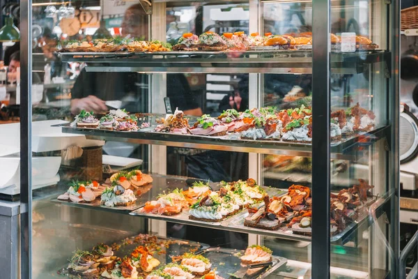 Copenhagen food market in Denmark. Danish smorrebrod traditional open sandwich at Copenhagen restaurant store. Many sandwiches on display with seafood and meat, smoked salmon, garnish, cold cuts