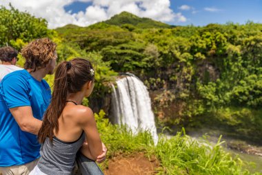 Couple tourists at Hawaii Kauai waterfall clipart
