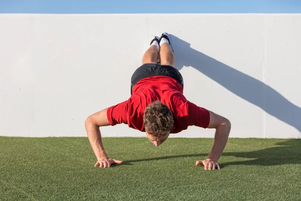 Liegestütz-Training mit Wand-Liegestütz im Outdoor-Fitnessstudio. Männlicher Fitness-Athlet macht fortgeschrittene Liegestütze auf dem Rasenplatz — Stockfoto