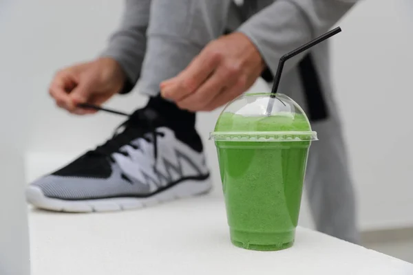 Batido verde hombre atando zapatillas cordones listos para correr en la ciudad urbana. Vida activa saludable, primer plano de los formadores — Foto de Stock