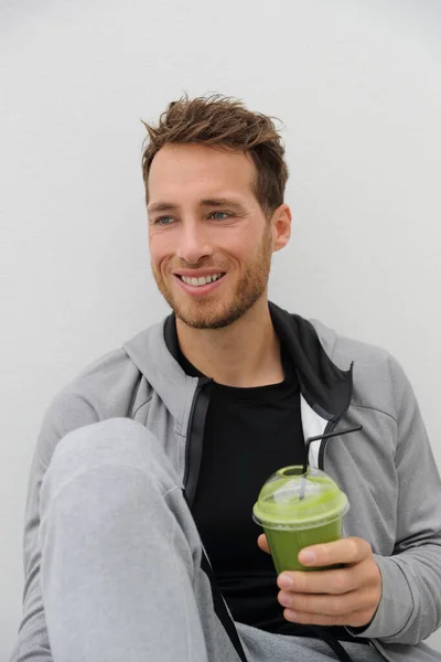Grön smoothie hälsosam kost man dricker detox grönsaksjuice rengöra. Sport idrottare som håller plast kopp dryck för morgon frukost — Stockfoto