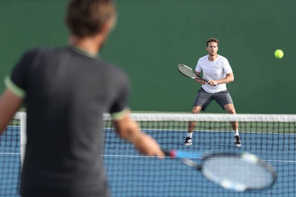 Mężczyźni sport sportowcy grający w tenisa mecz razem. Dwóch profesjonalnych tenisistów uderzających piłkę na twardym korcie podczas gry — Zdjęcie stockowe