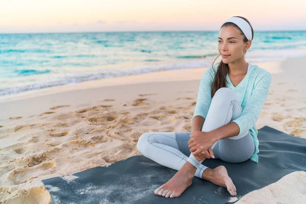 Yoga yapan plaj kadını spor minderinde dinleniyor. — Stok fotoğraf