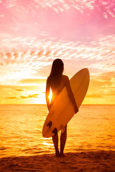 Strand zonsondergang sexy surfer vrouw surfen levensstijl ontspannen holding surfplank kijken naar oceaan golven om te surfen. Actief gezond leven silhouet van sporter staan in de kleurrijke hemel — Stockfoto