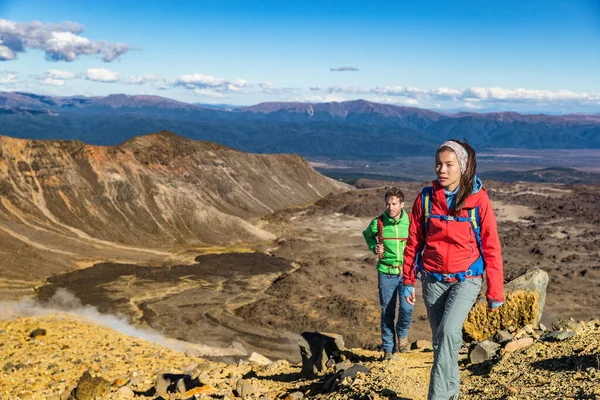 Turyści wędrowcy wędrujący po górach w wędrówce wysokościowej. Para turystów włóczących się po Nowej Zelandii podczas wędrówki po Tor Alpejski Tongariro, NZ. Podróże plecak styl życia — Zdjęcie stockowe