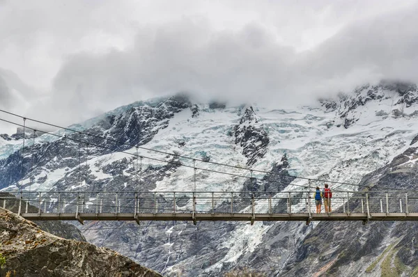 Hooker Valley Track trilha de caminhada, Nova Zelândia. Segunda ponte de balanço que cruza o rio na trilha de Hooker Valley, Aoraki, Mt Cook National Park com paisagem de montanhas cobertas de neve — Fotografia de Stock