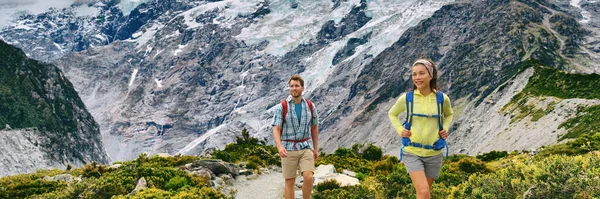 뉴질랜드 배낭 여행자들은 후커 밸리 트랙 (Hooker Valley Track) 을 도보 여행 한다. 산의 자연 풍경은 파노라마 깃발이다. 모험을 즐기는 부부 — 스톡 사진