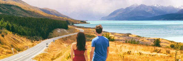 Nueva Zelanda viaja gente mirando el Monte Cook Aoraki lejos en el paisaje. Pareja de turistas caminando en el mirador de Peters, espacio de copia panorámica de la bandera en el fondo — Foto de Stock