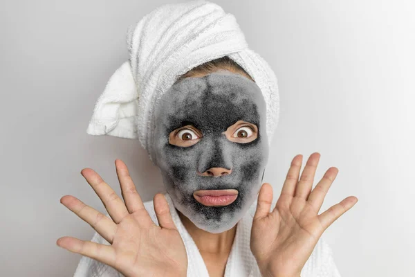 Face mask bubble foam facial funny woman at beauty spa looking shocked or surprised, scary chemicals in beauty products. Asian girl wearing bath towel on hair. — Stock fotografie