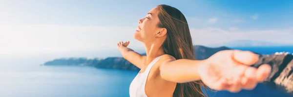 Crociera in Europa Santorini viaggiare banner donna libera. Grecia vacanza spensierata libertà a braccia aperte nella famosa vacanza di viaggio. Elegante ragazza asiatica in viaggio greco resort di lusso a Oia Santorini — Foto Stock