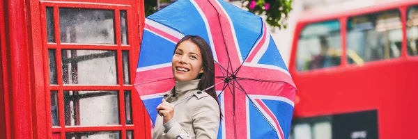 Лондонская туристка-путешественница баннер с копирайтом, знаменитым городским отпуском. Азиатка с британскими иконами, красная телефонная будка, большой автобус — стоковое фото