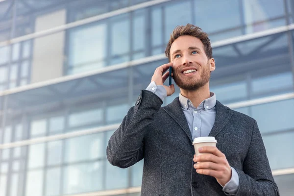 Muž mluví na smartphonu. Podnikatel městský profesionální podnikatel pomocí mobilního telefonu s úsměvem pije kávu v kancelářské budově ve městě. Šťastný profesionál v obleku — Stock fotografie